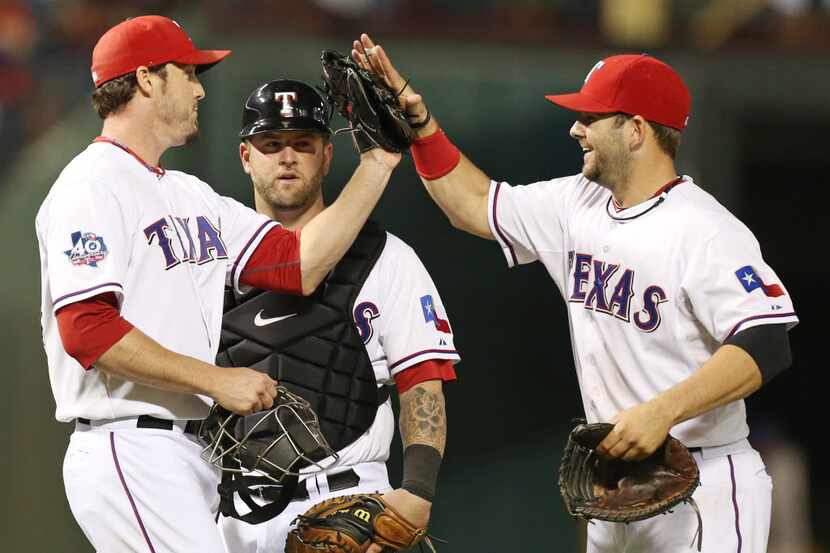 Texas closer Joe Nathan, left, is congratulated by first baseman Mitch Moreland and catcher...