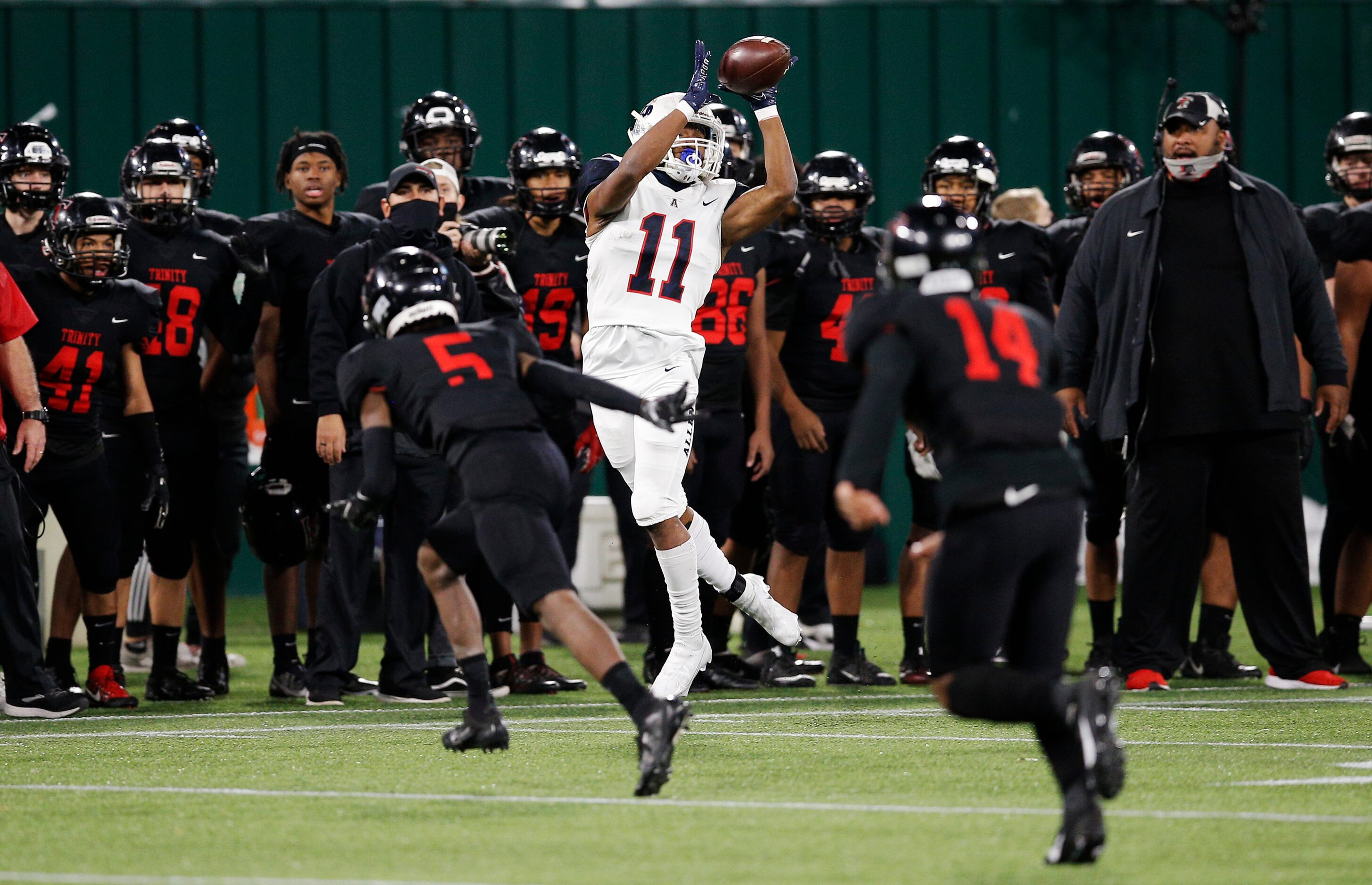 Allen senior wide receiver Jordan Johnson (11) catches a pass as Euless Trinity junior...