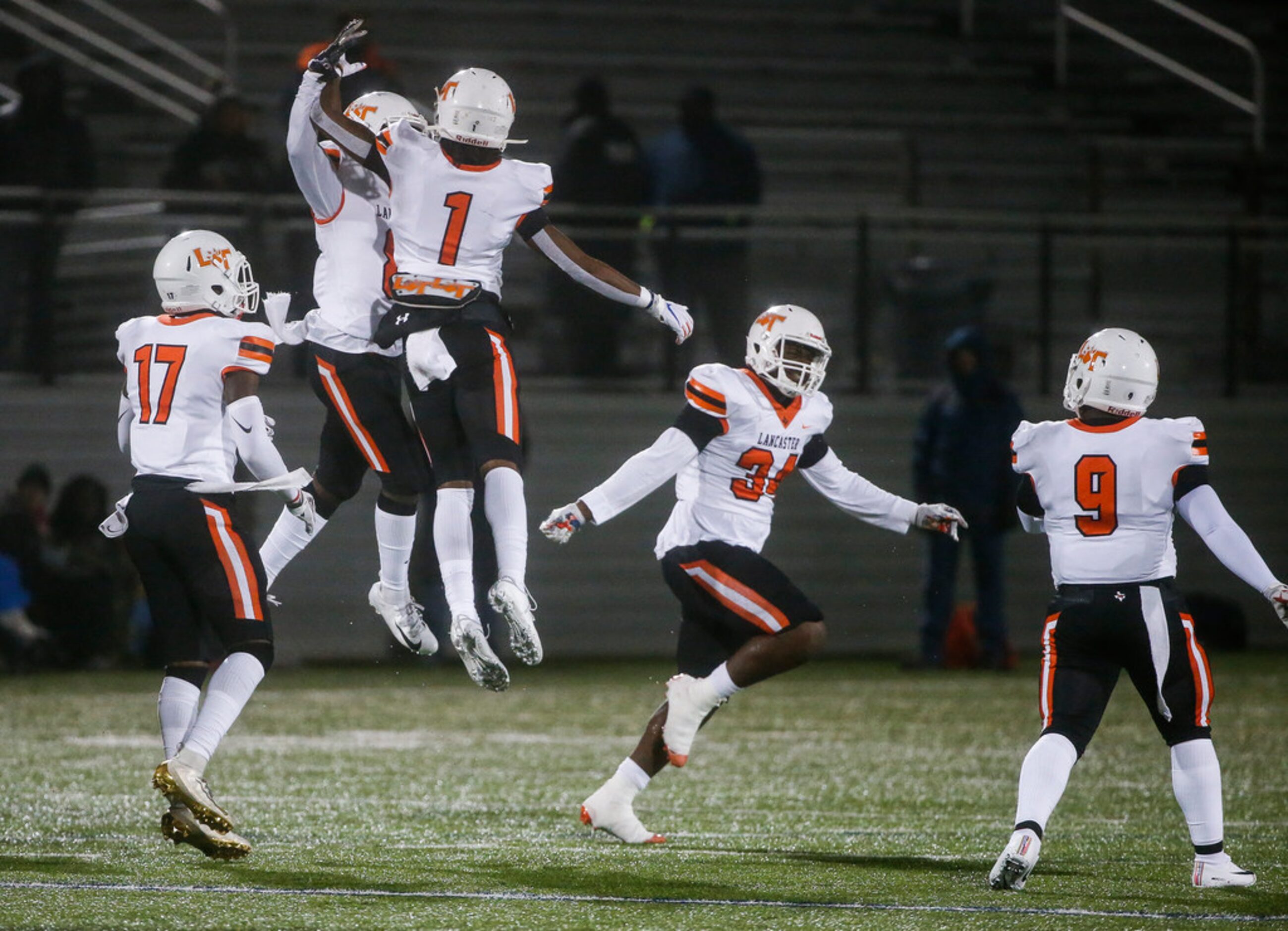 The Lancaster Tigers celebrate a interception by defensive back Davion Hodge (8) during a...