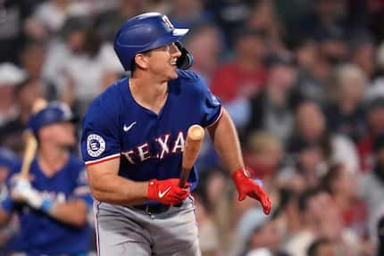 Texas Rangers' Wyatt Langford watches the flight of his three-run home run in the ninth...