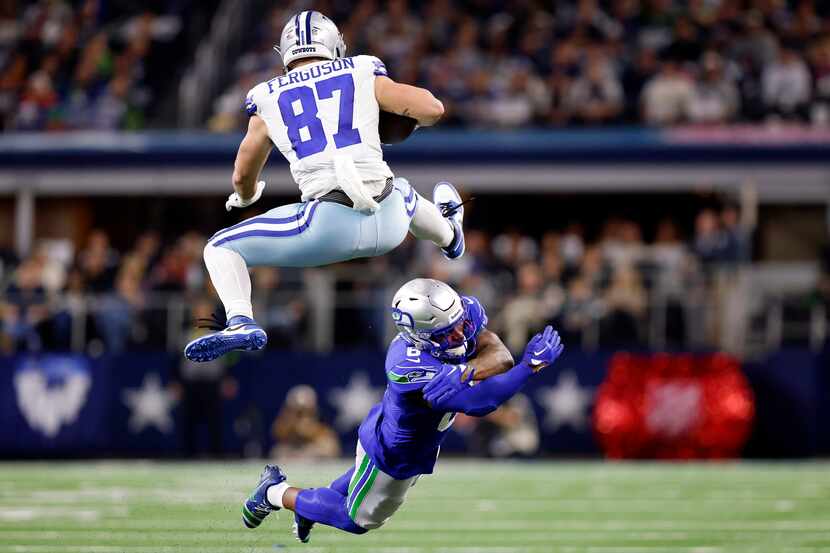Dallas Cowboys tight end Jake Ferguson (87) hurdles the tackle attempt by Seattle Seahawks...