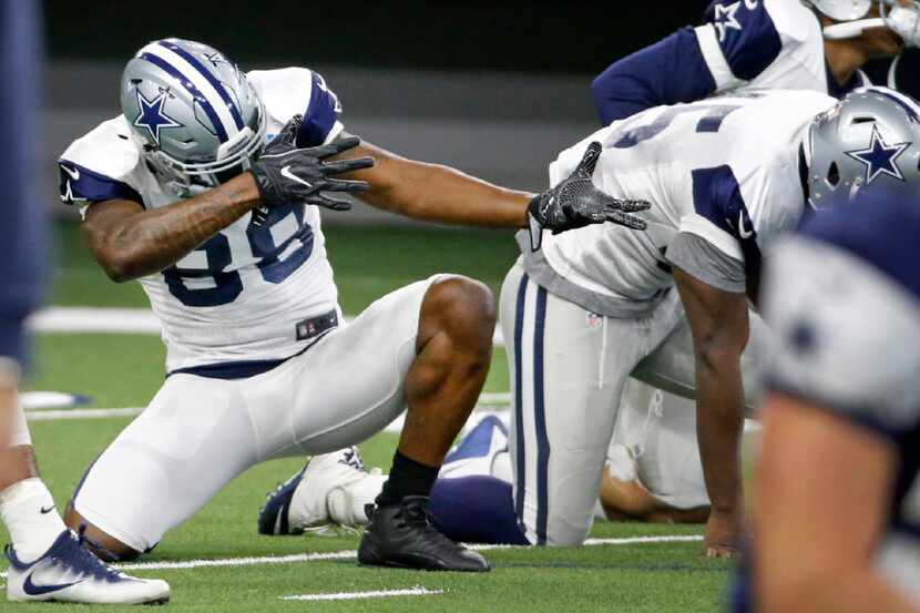 Dallas Cowboys wide receiver Dez Bryant (88) clowns around during stretching exercises...