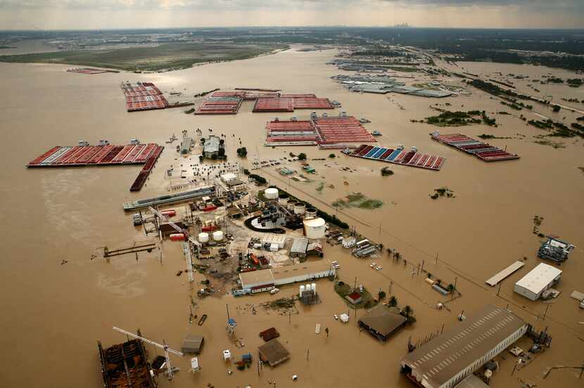 Barges were secured by tugboats in flood-swollen Burnet Bay along the Houston Ship Channel...