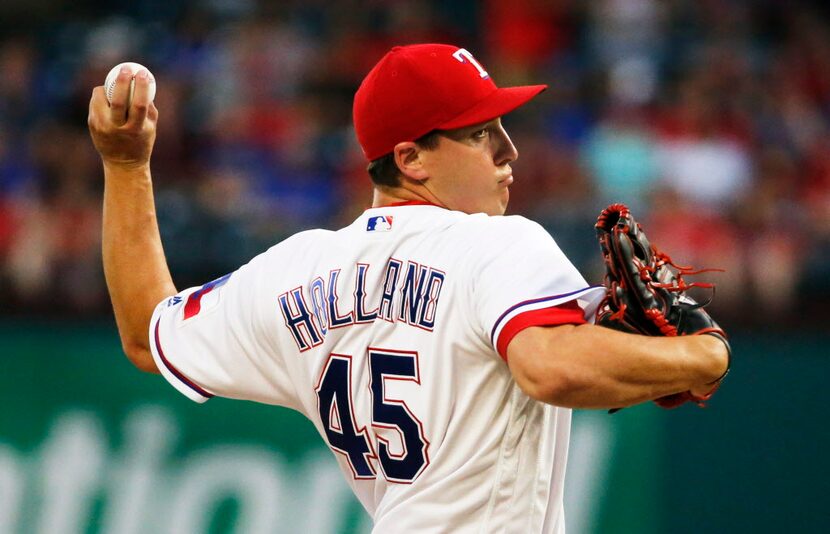 Texas Rangers starting pitcher Derek Holland (45) throws a first-inning pitch during the Los...