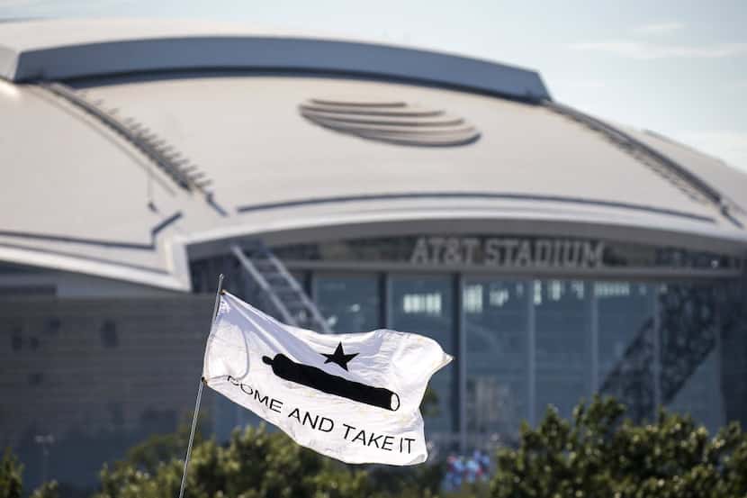 A Come and Take It flag flies outside the stadium as Dallas Cowboys fans tailgate before an...