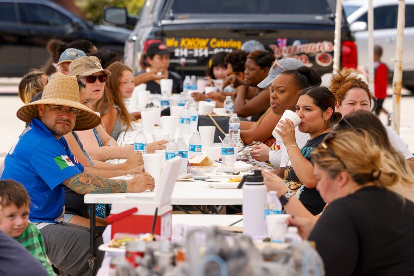 Residents of the Spring Ridge neighborhood and volunteers eat lunch during an event to...