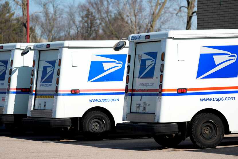 FILE - U.S. Postal Service trucks park outside a post office, Jan. 29, 2024, in Wheeling,...