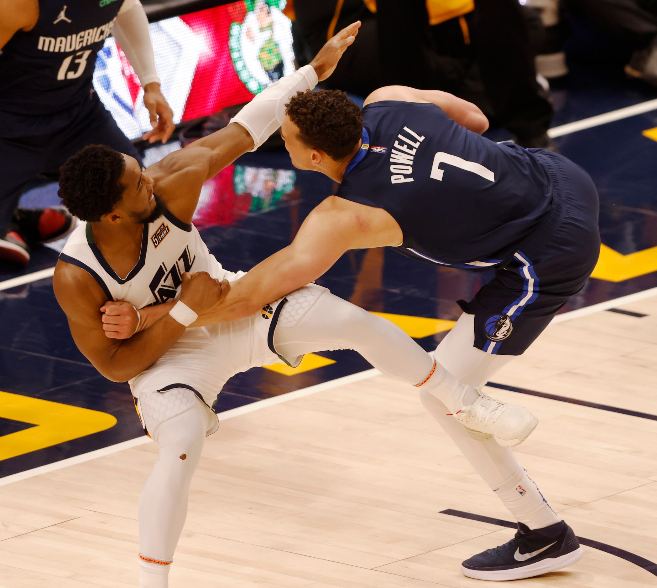 Dallas Mavericks center Dwight Powell (7) is fouled by Utah Jazz guard Donovan Mitchell (45)...