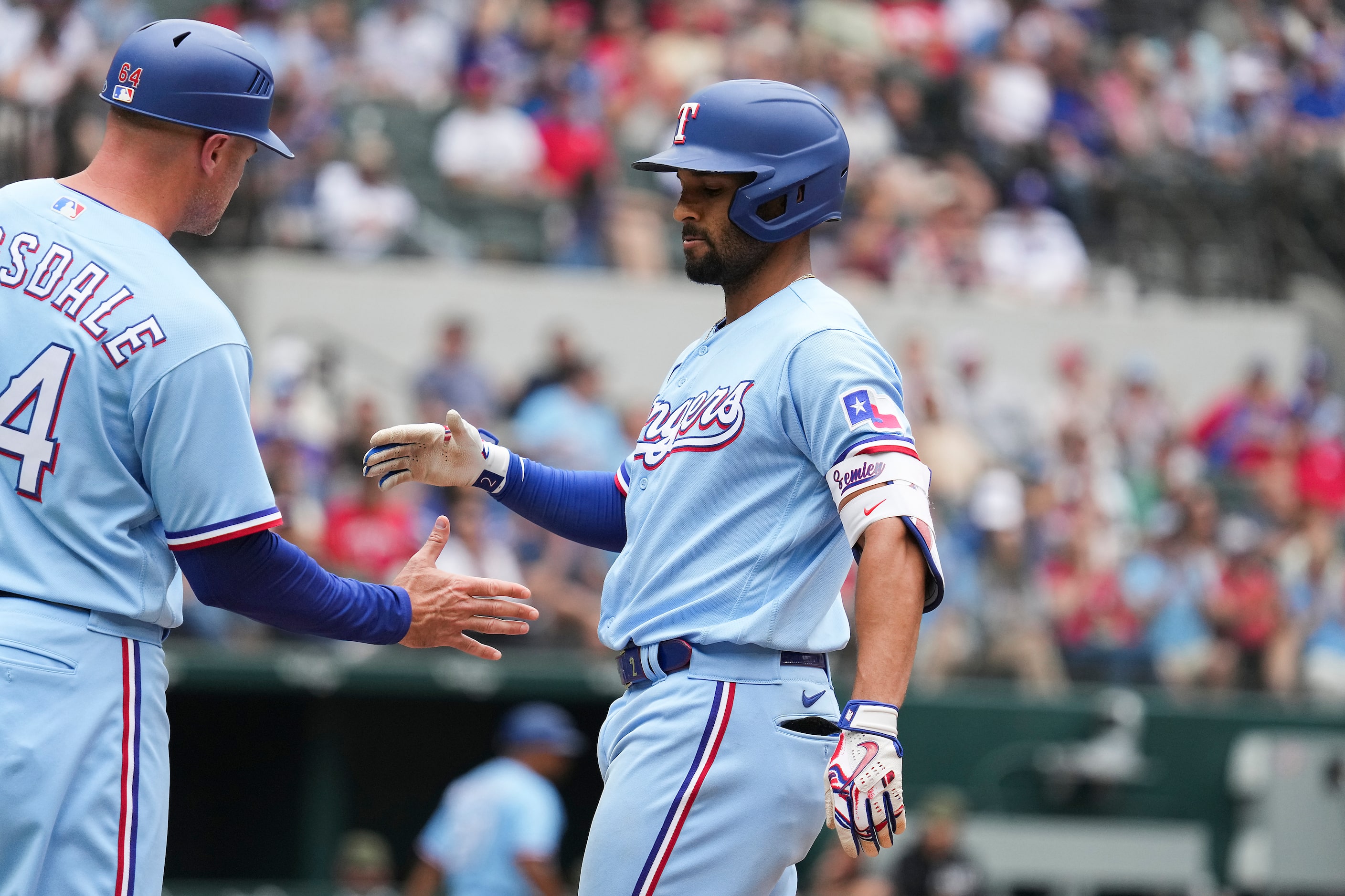 Texas Rangers second baseman Marcus Semien celebrates with first base coach Corey Ragsdale...