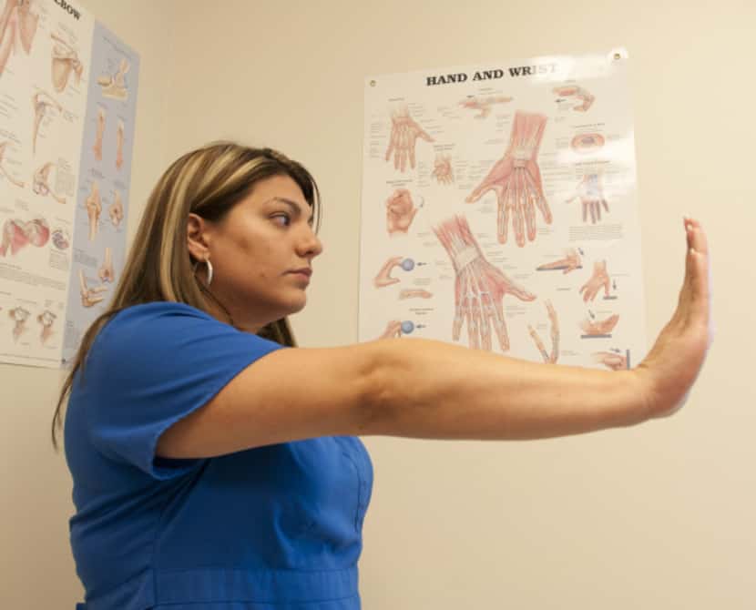 Brenda Alvarez demonstrates Step 5 of an arm exercise to alleviate hand pain.