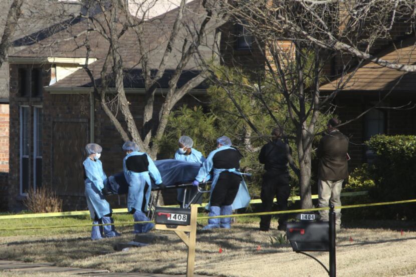 A body is removed from a home on Paintbrush Street as police investigate the deaths of four...