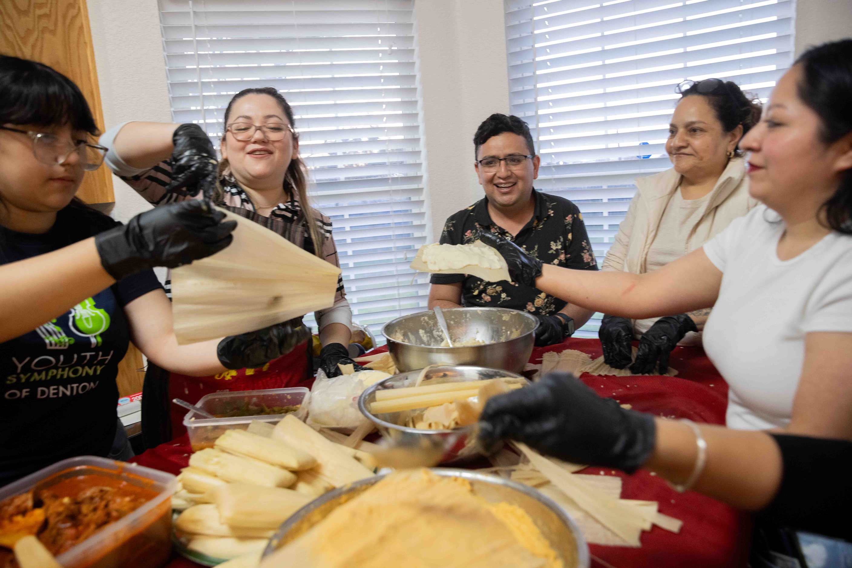 (From left) Aria García helps mom Sara Klein, the hostess behind the evening’s “tamalada,”...