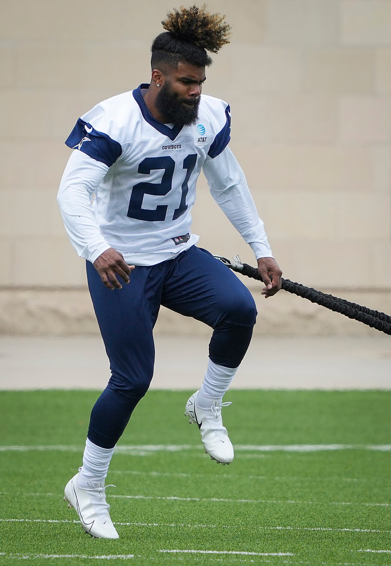 Dallas Cowboys running back Ezekiel Elliott works with a resistance band during a minicamp...