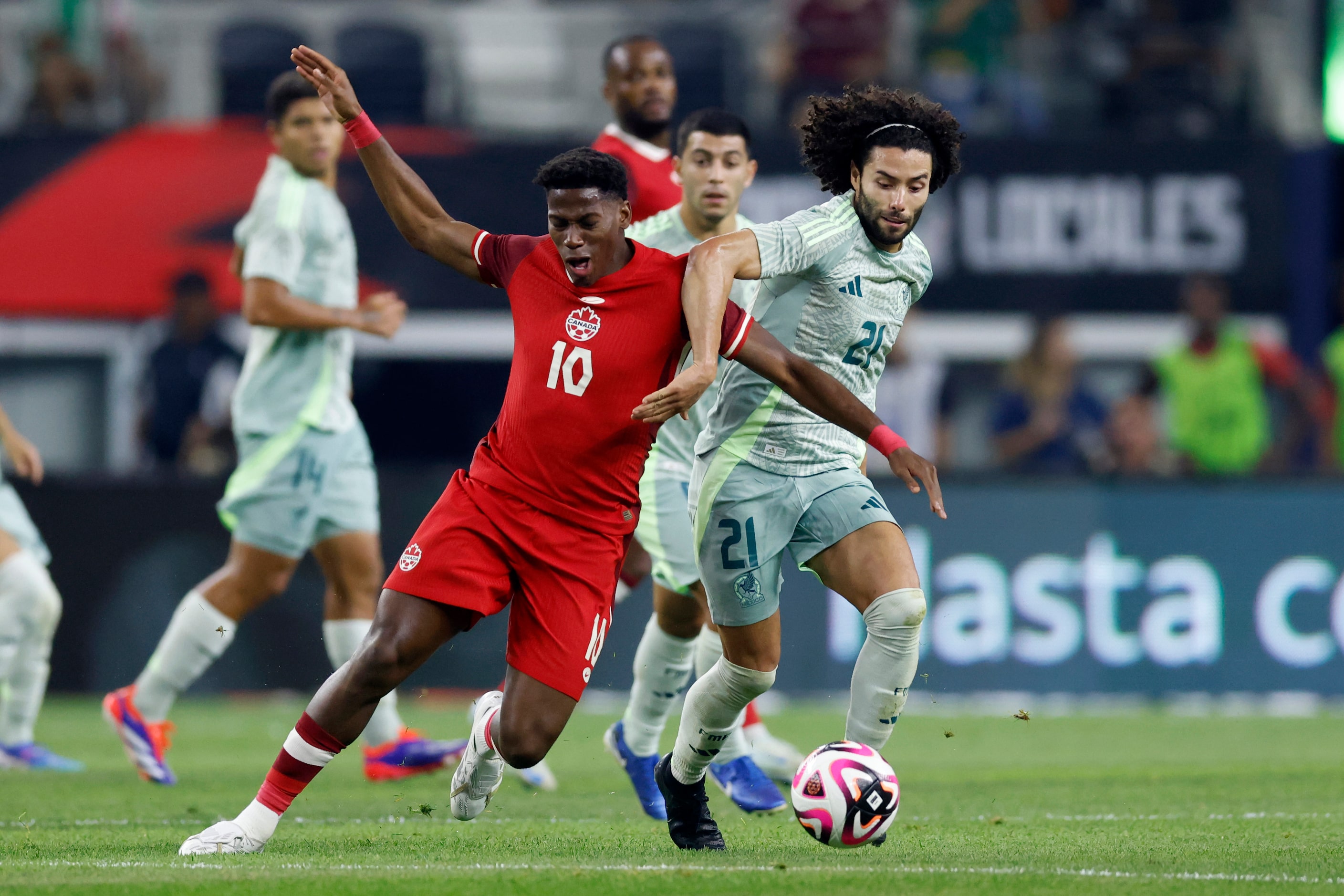 Canada forward Jonathan David (10) falls to the ground as he battles for the ball against...