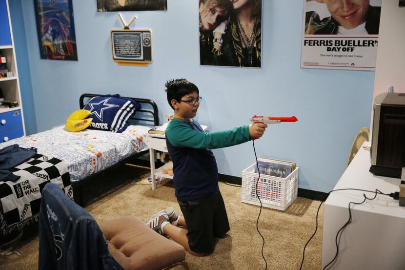 Ten-year-old Frankie Valenzuela takes aim while playing Duck Hunt in the 1980s-themed room...