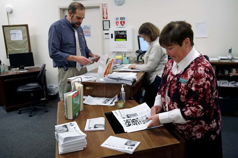 Librarian Thelma Tracy, right, folds editions of the "Weare in the World" with her...