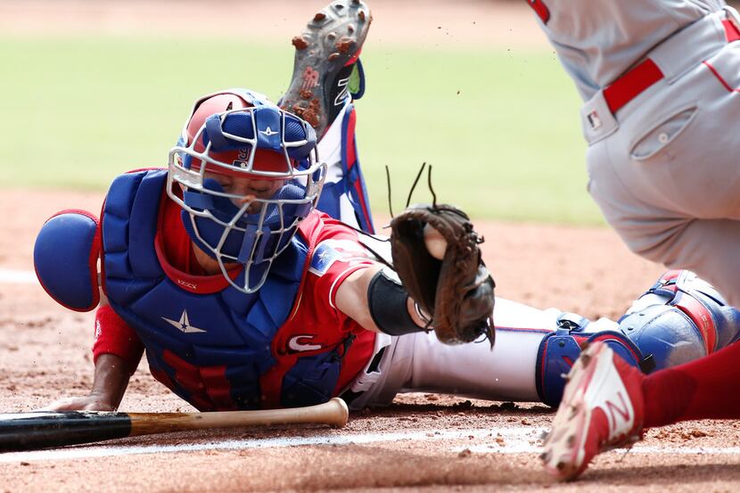 Texas Rangers catcher Isiah Kiner-Falefa, left, is unable to get the tag on Los Angeles...