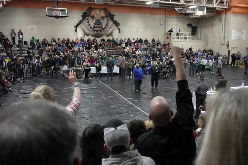 A man raises his hand with a question for East Palestine, Ohio Mayor Trent Conaway, center,...