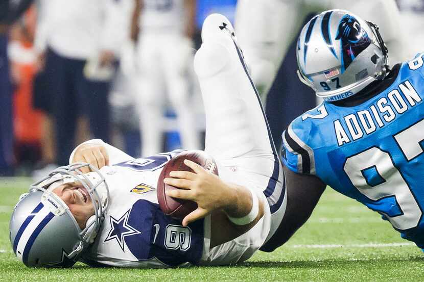 Dallas Cowboys quarterback Tony Romo (9) grimaces as he rests on the turf after being sacked...