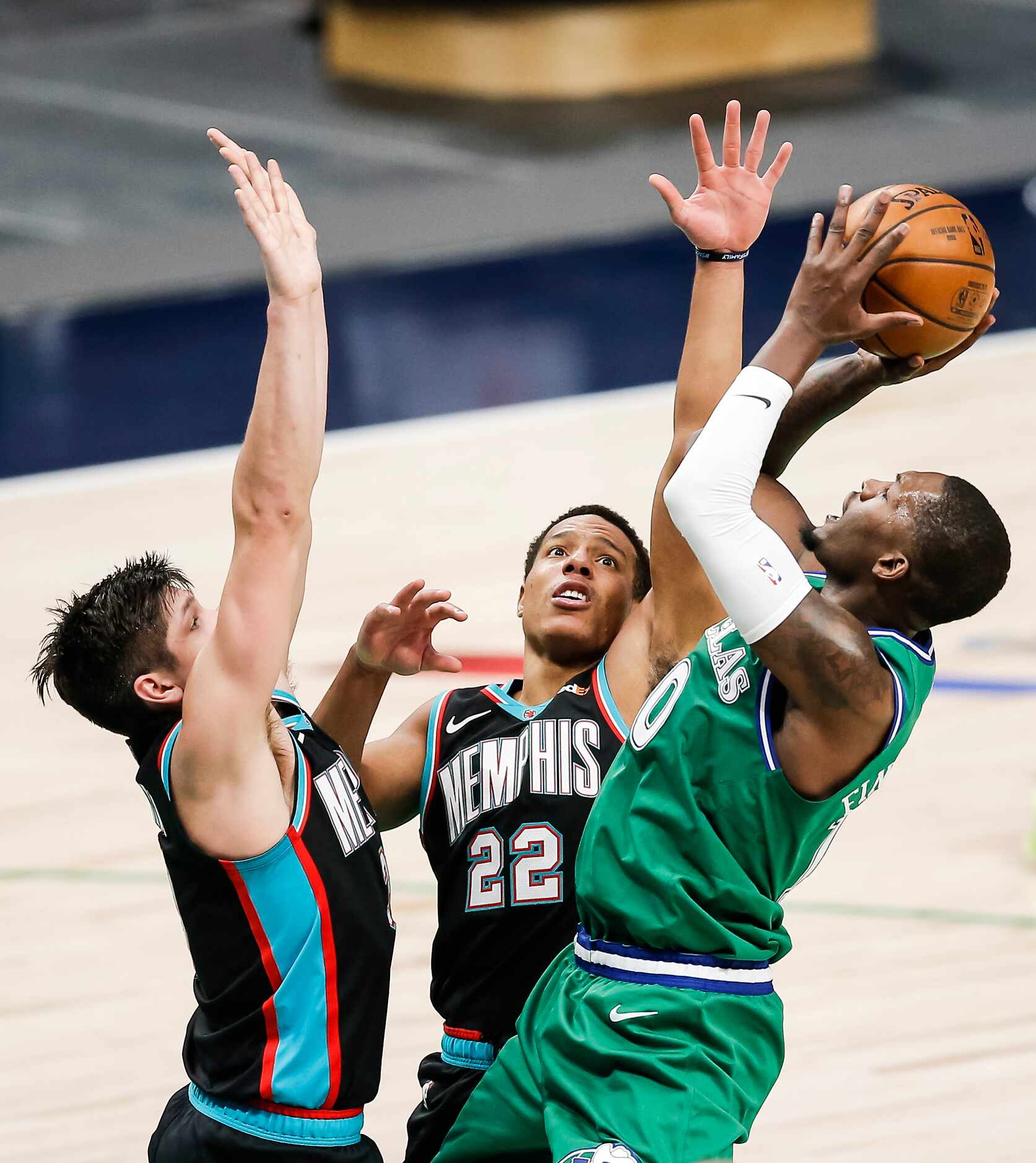 Dallas Mavericks forward Dorian Finney-Smith, right, attempts a shot as Memphis Grizzlies...