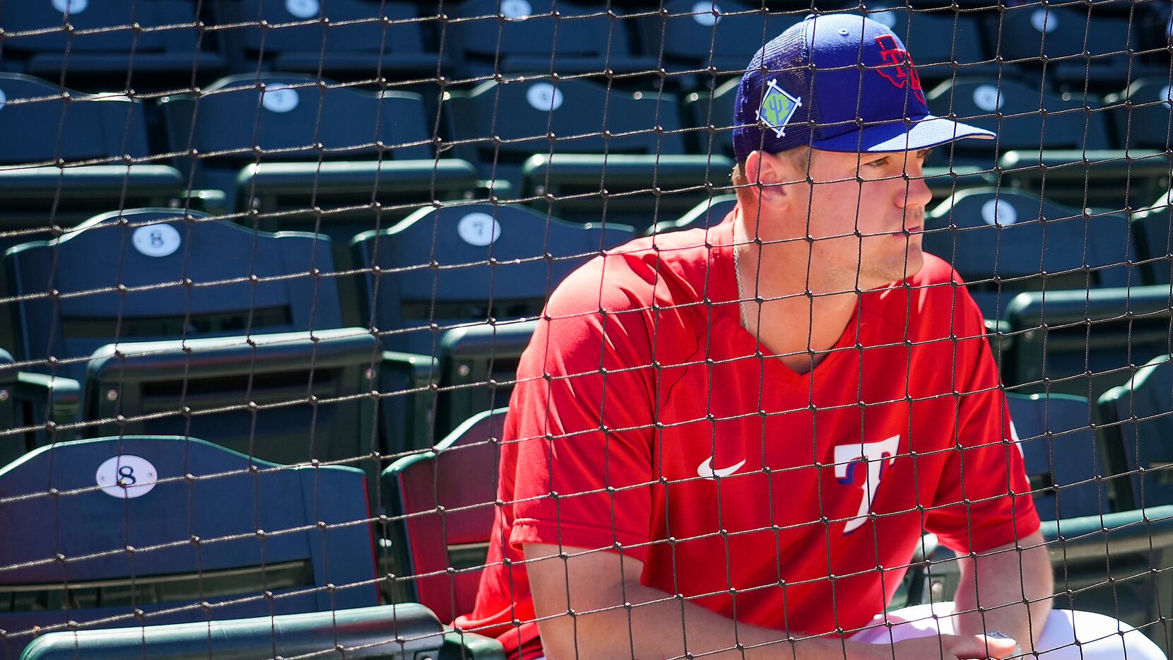Texas Rangers infielder Josh Jung watches from the stands before a spring training game...