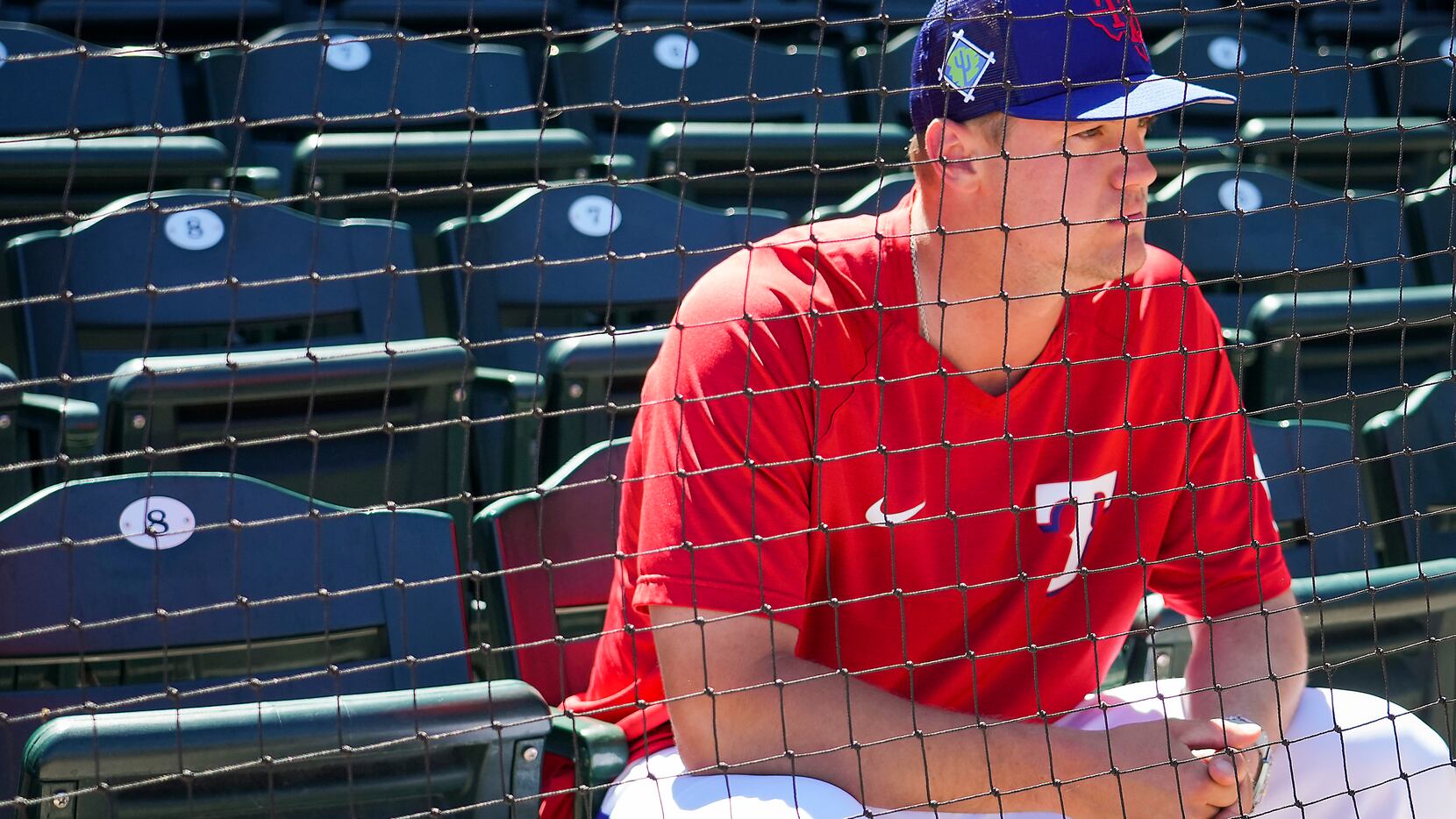Texas Rangers infielder Josh Jung watches from the stands before a spring training game...