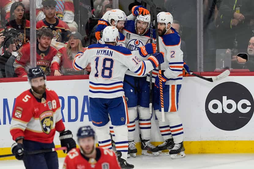 Edmonton Oilers center Connor McDavid (97), is congratulated by his teammates after scoring...