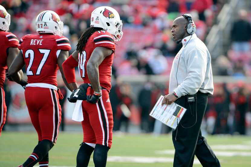Nov 23, 2013; Louisville, KY, USA; Louisville Cardinals head coach Charlie Strong talks with...