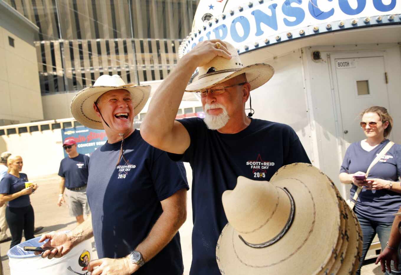 Scott + Reid General Contractors vice president and partner Jeff Reid (right) tries on straw...