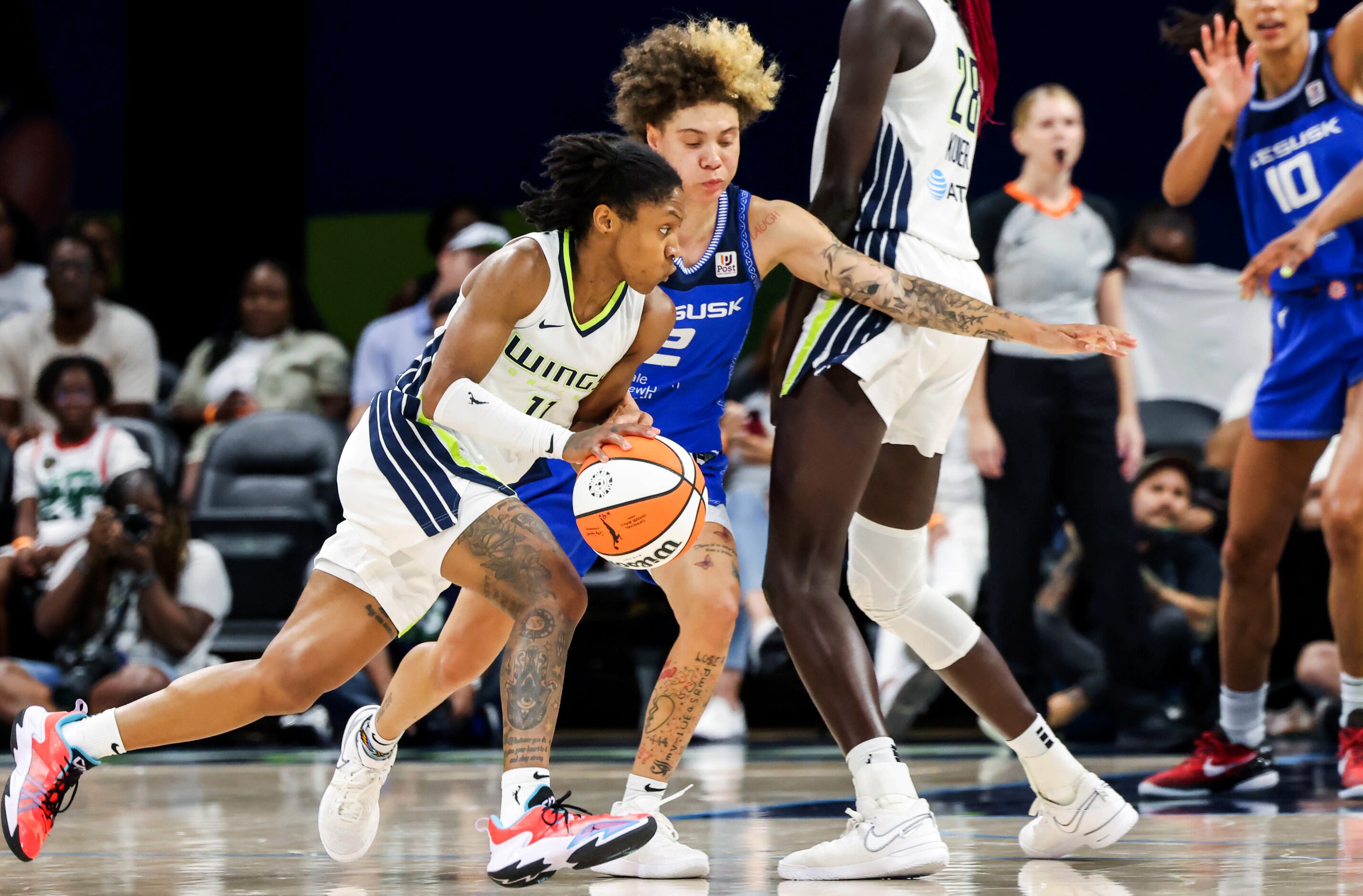 Dallas Wings guard Crystal Dangerfield (11) drives past Connecticut Sun guard Natisha...