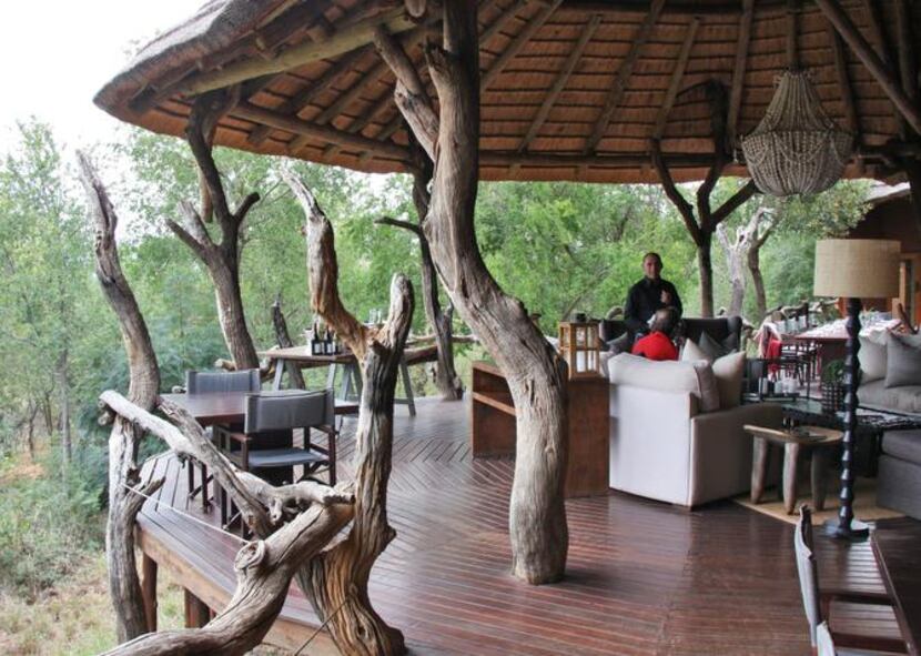 
Guests relax in the open-air lounge area at Madikwe Safari Lodge with sparkling wine and...