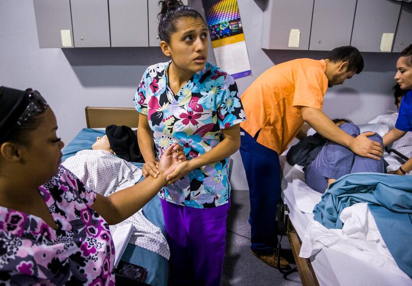 
Tamia Holland (left) has her pulse taken by Stephanie Mora (center) while Martin Hernandez...