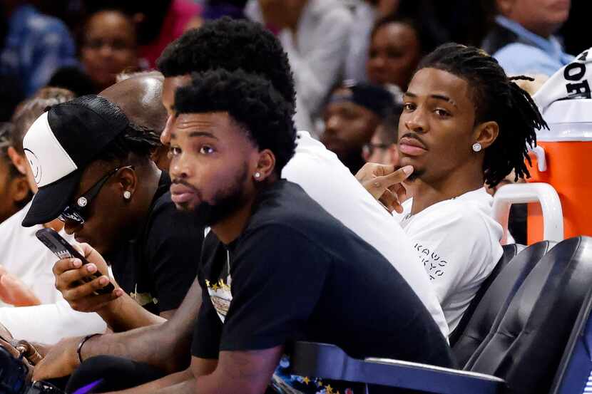 Memphis Grizzlies star guard Ja Morant (right) watches the Dallas Wings and Connecticut Sun...