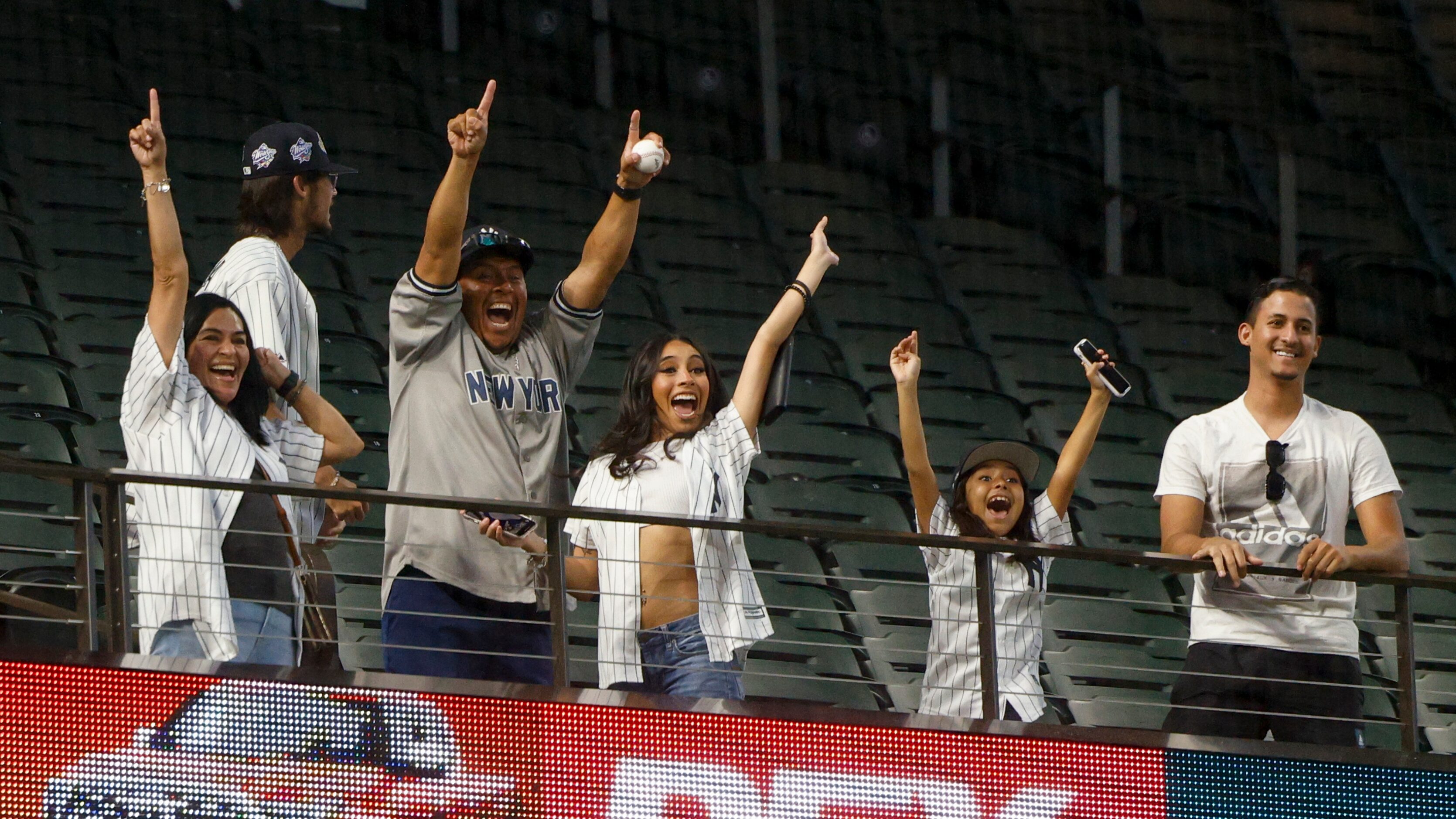 Fans celebrate after catching a ball thrown from New York Yankees right fielder Aaron Judge...