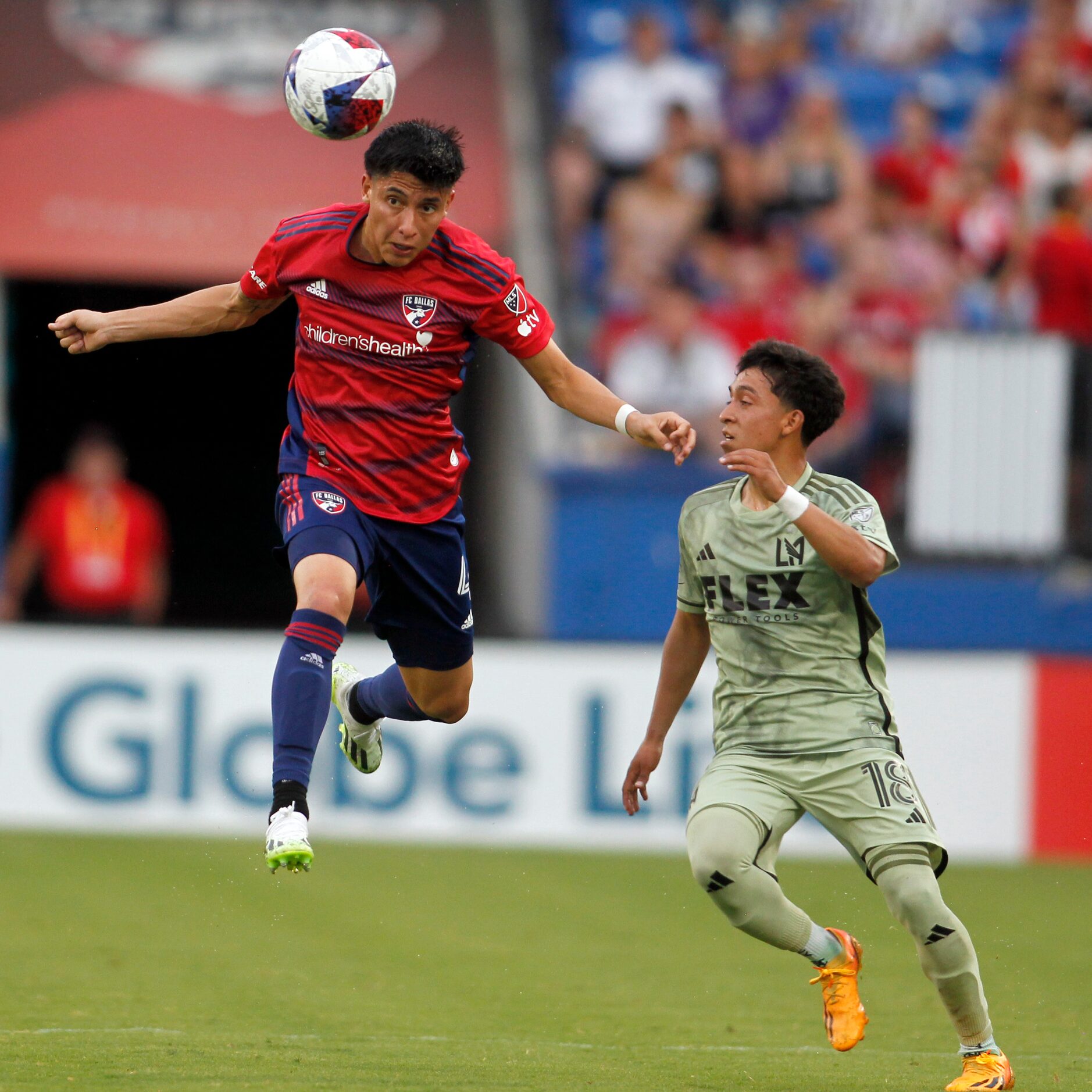 FC dallas defender Marco Farfan (4) heads the ball to a teammate over the defense of LA Fc...