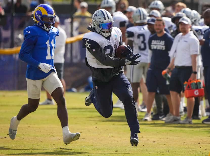 Dallas Cowboys running back Ezekiel Elliott (21) gets past Los Angeles Rams defensive back...