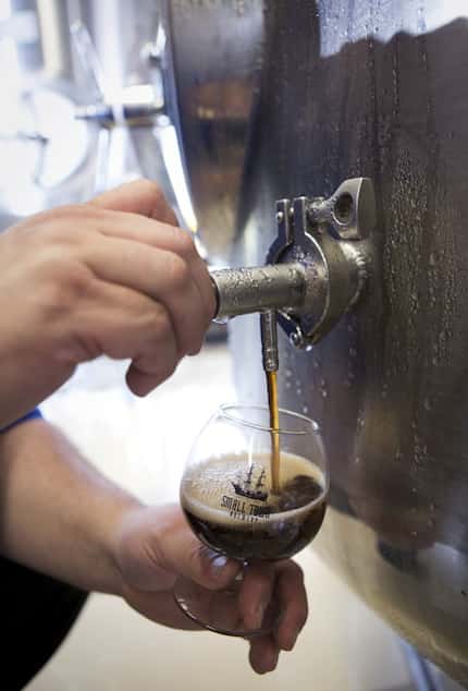 Tim Kovac taps a glass of Not Your Father's Root Beer before filling kegs of the 10.7...
