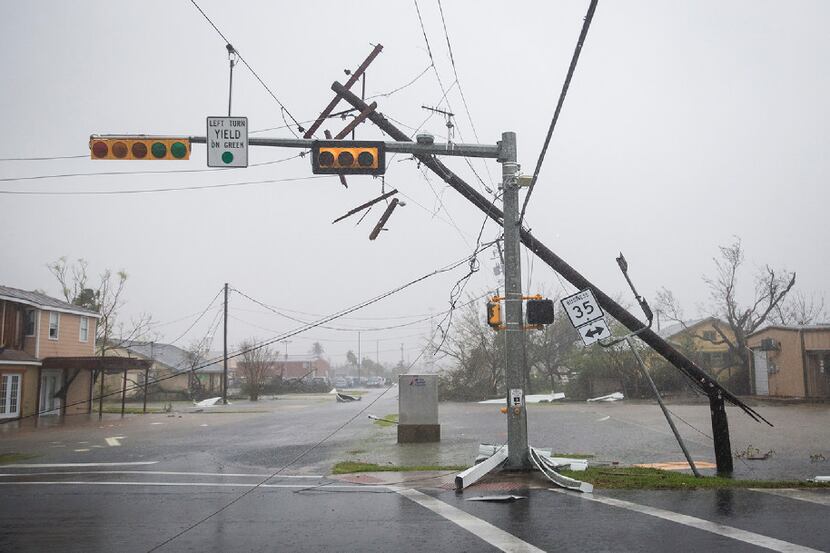 A snapped power pole leans against a stoplight after Hurricane Harvey ripped through...