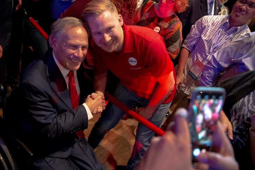 Texas Gov. Greg Abbott poses for a photo with a supporter during the Texas GOP election...