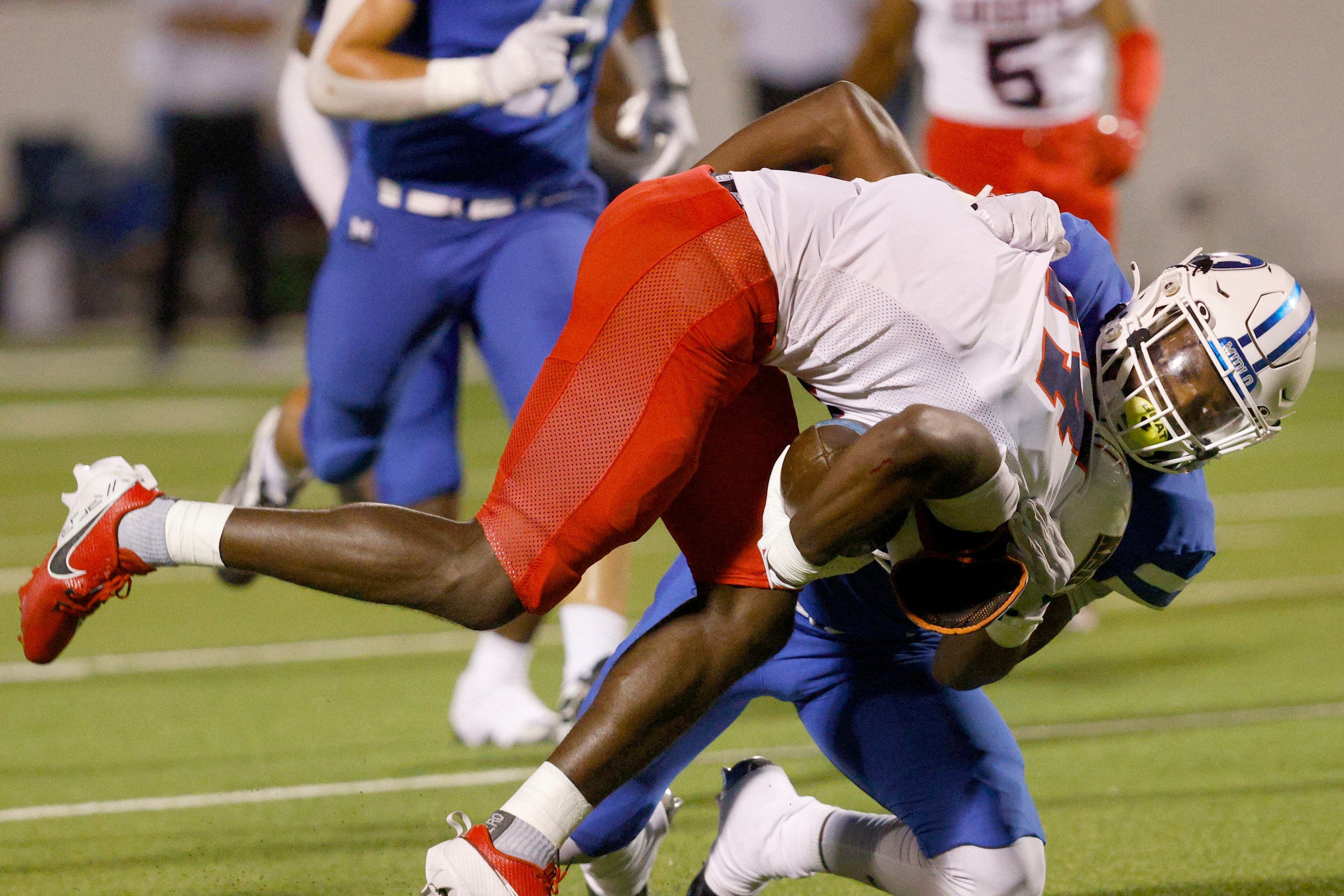 Kimball's Christian Witherspoon (14) is tackled by Midlothian's Dejasper Webb (7) in the...