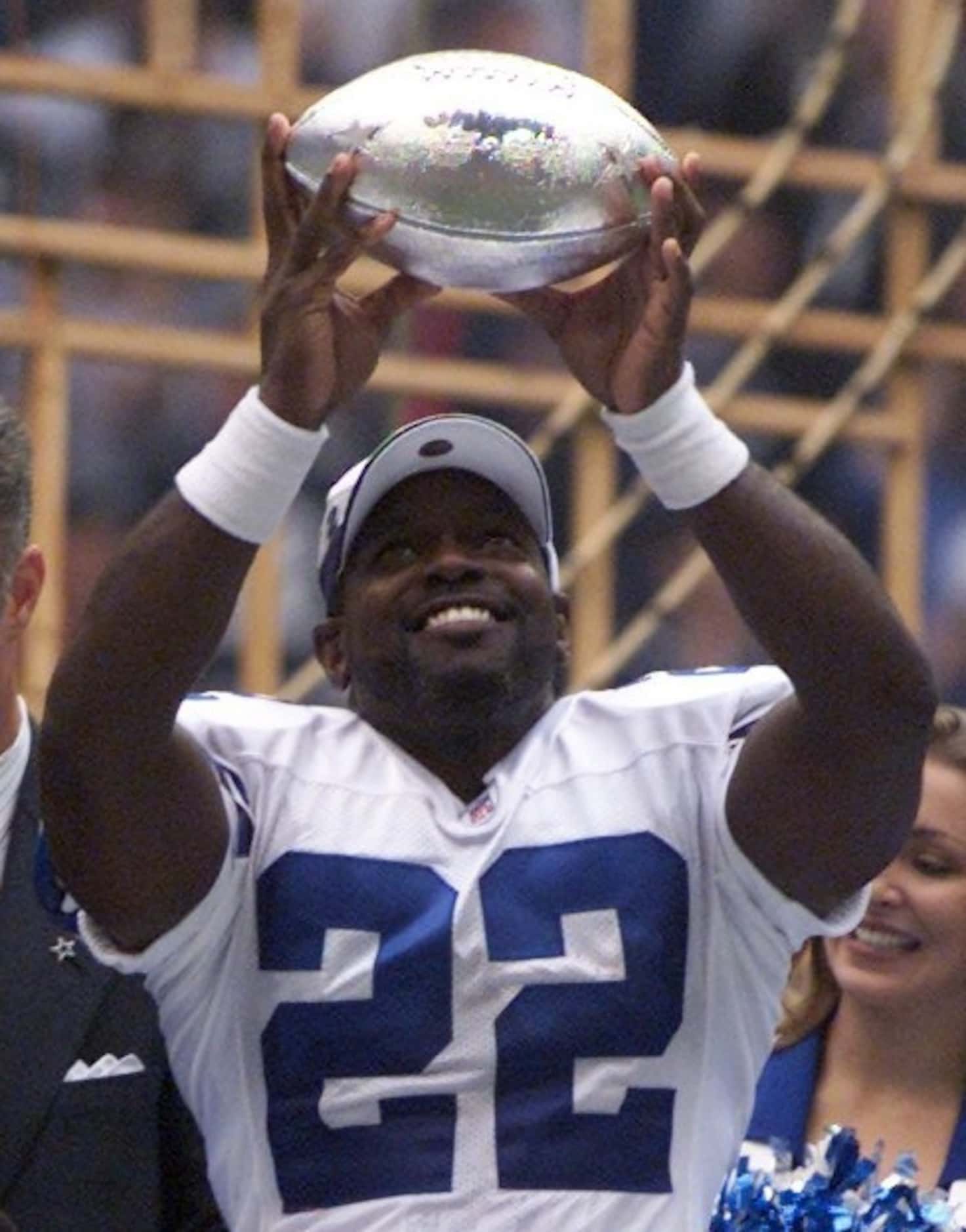 Dallas Cowboys rrunning back Emmitt Smith holds up the NFL rushing trophy during a post-game...