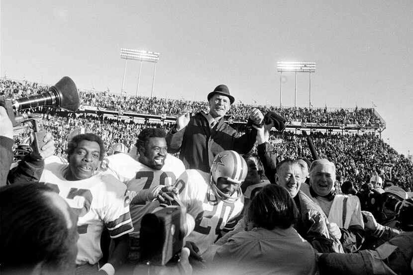 Dallas Cowboys coach Tom Landry is carried off the field on the shoulders of his players...