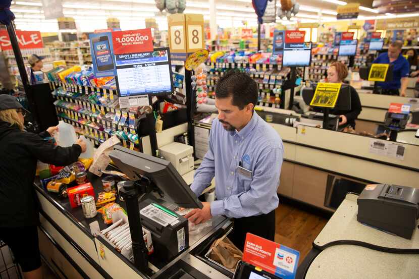 Shaun Paeth, head of general merchandise, jumps on the register at Albertson's on March 20,...