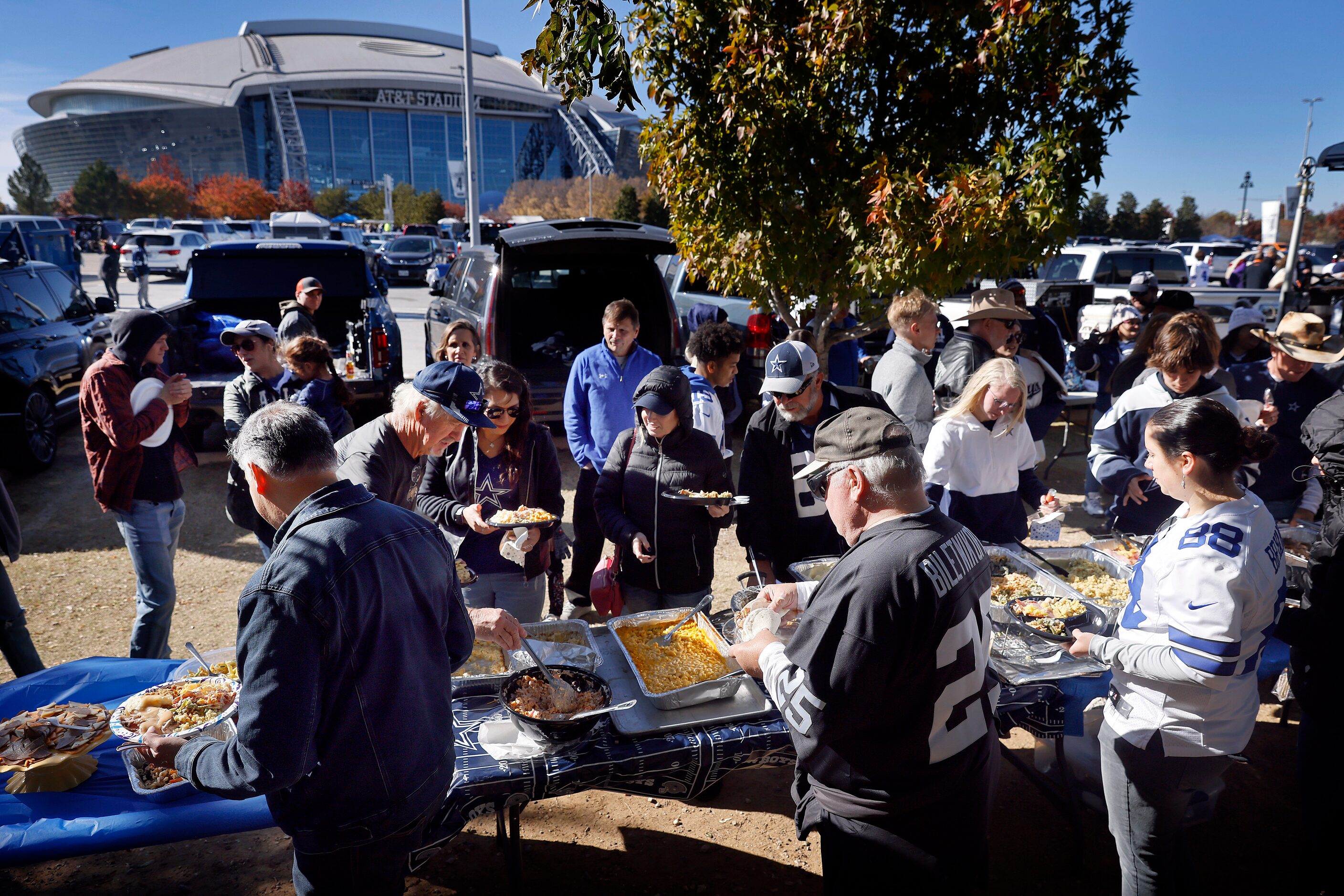 Dallas Cowboys fans dig into a Thanksgiving feast during at tailgate party outside of AT&T...