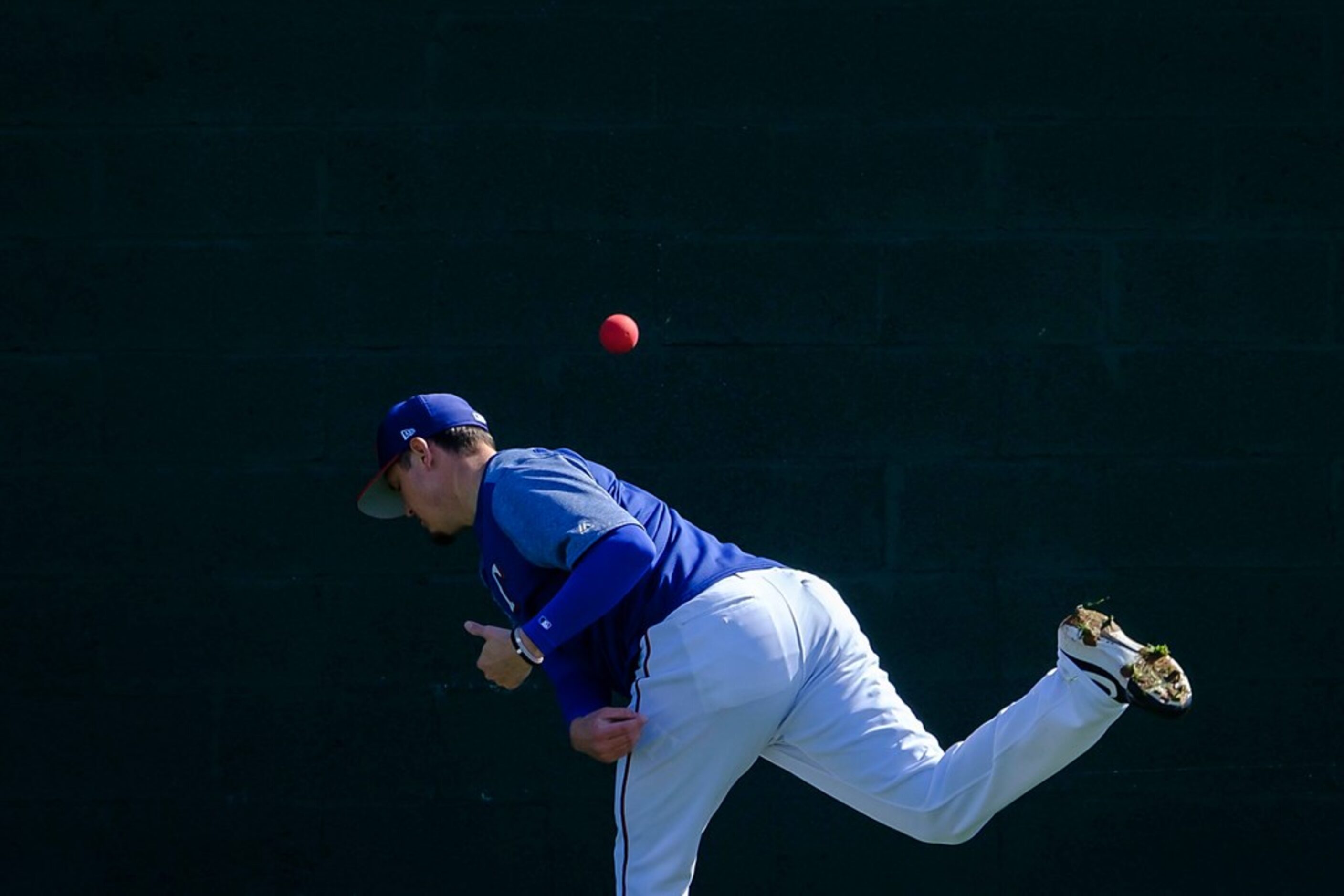 Texas Rangers pitcher Nick Gardewine throws a heavy ball against a bullpen wall during a...