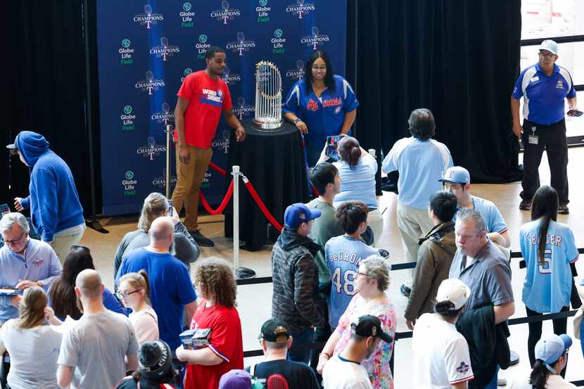 Fans wait in line to take a photo with the Commissioner's Trophy during Texas Rangers Fan...