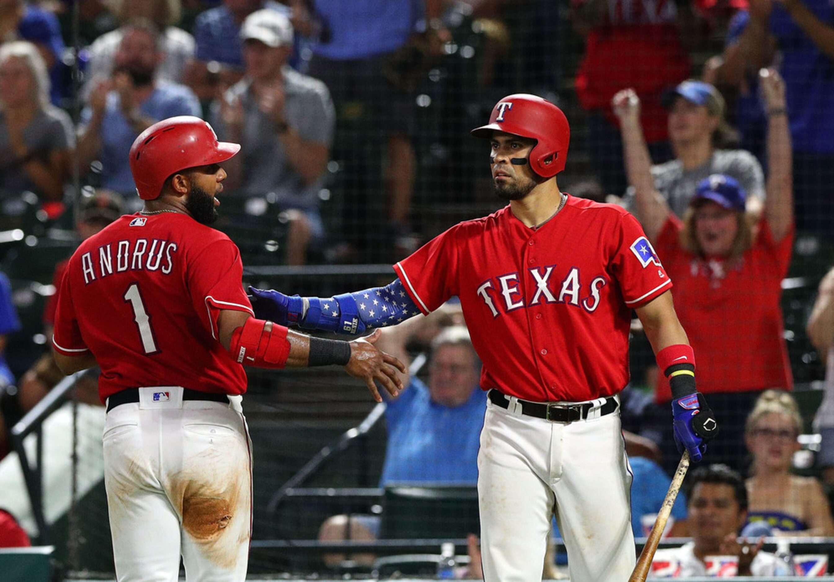 ARLINGTON, TX - SEPTEMBER 03:  Elvis Andrus #1 of the Texas Rangers is greeted by Robinson...