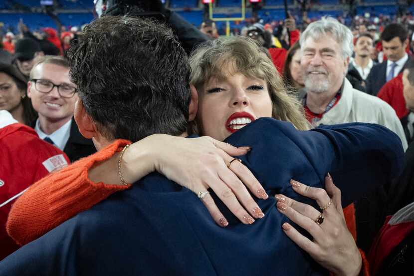 Taylor Swift hugs Tony Romo after an AFC Championship NFL football game between the Kansas...