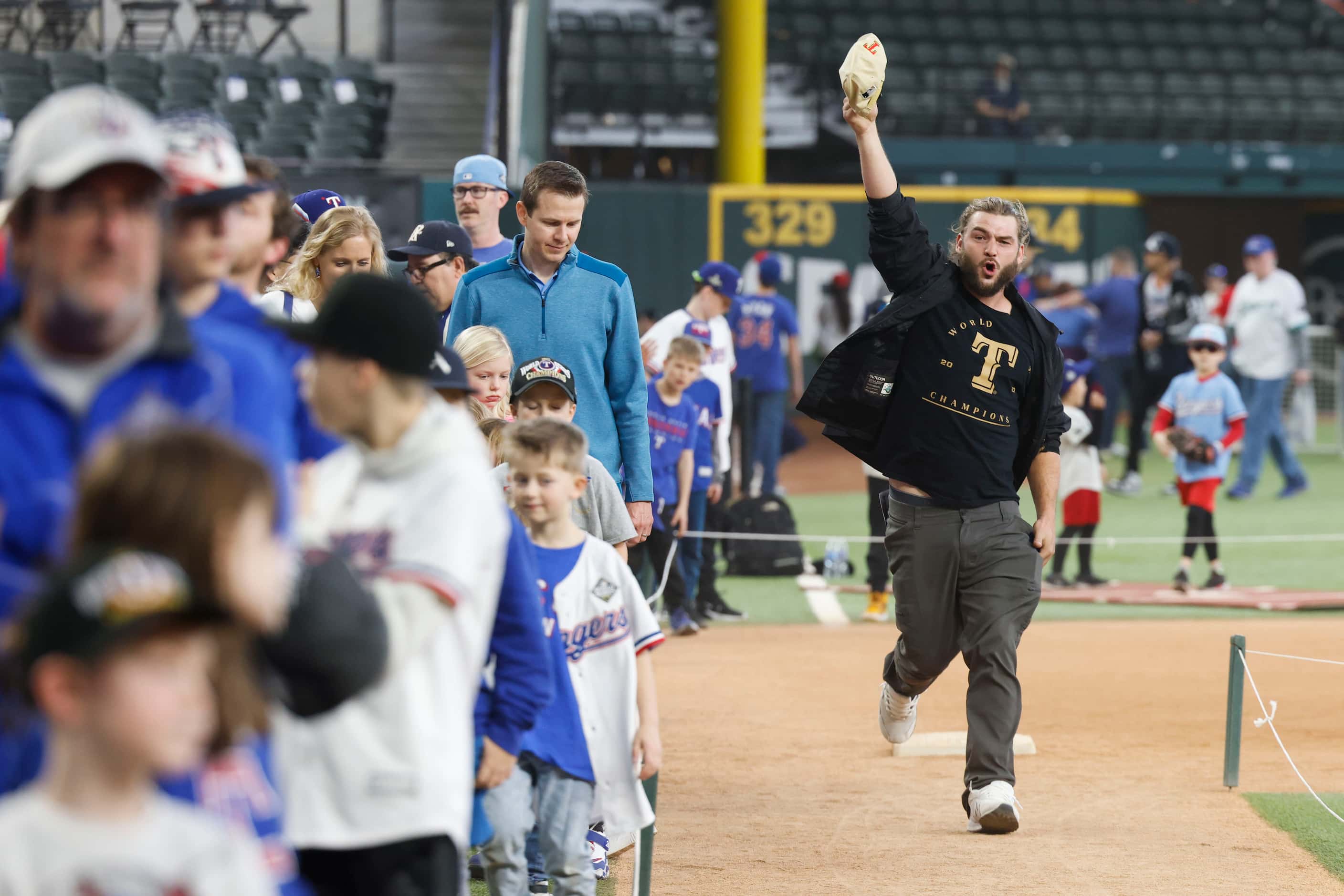 Casey Richardson cheers as he runs among the bases during Texas Rangers Fan Fest on,...