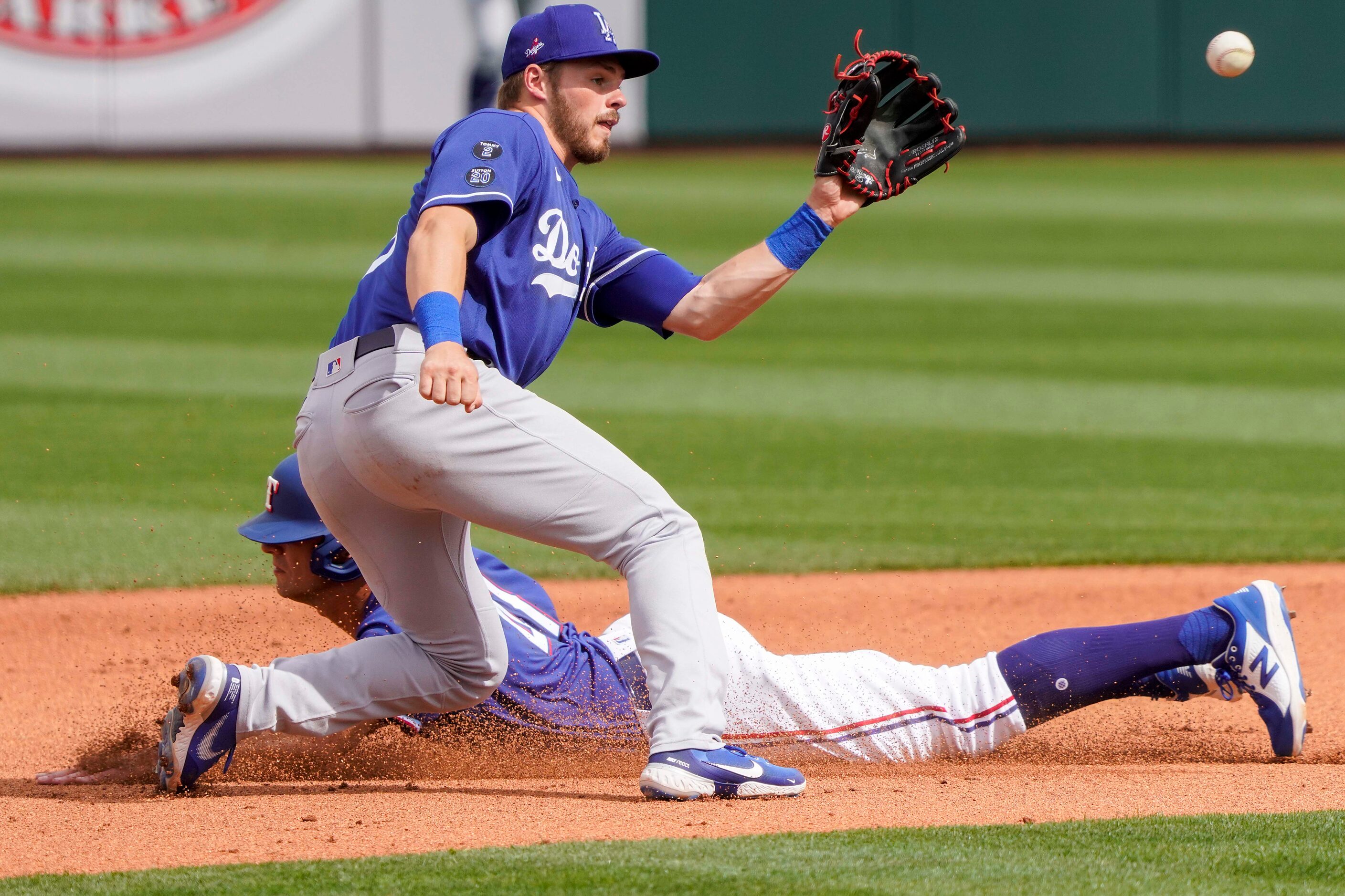 Texas Rangers outfielder Eli White steals second base ahead of the throw to Los Angeles...